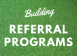 The text "building referral programs" over a background of grass.